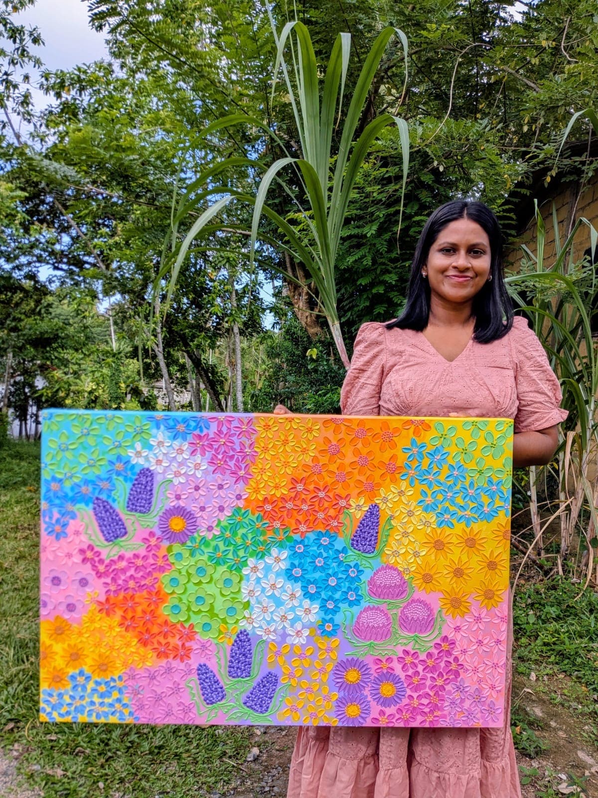 Malshi holding her painting Petals of Joy